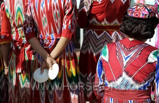 4月25日，身着新疆传统艾德莱斯服饰的妇女在等待表演婚庆舞蹈。.jpg.jpg